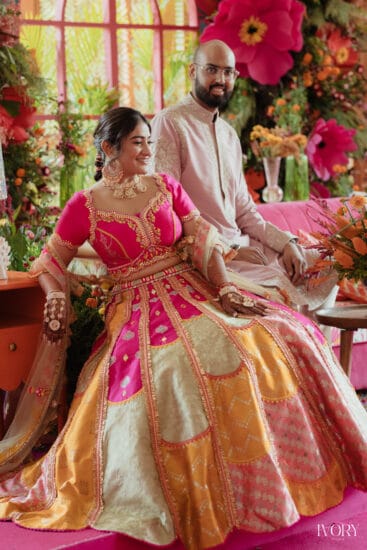 Bride dancing at vibrant Mexican-themed Mehendi with colourful decor, papel picado flags, taco bar, and festive floral arrangements.